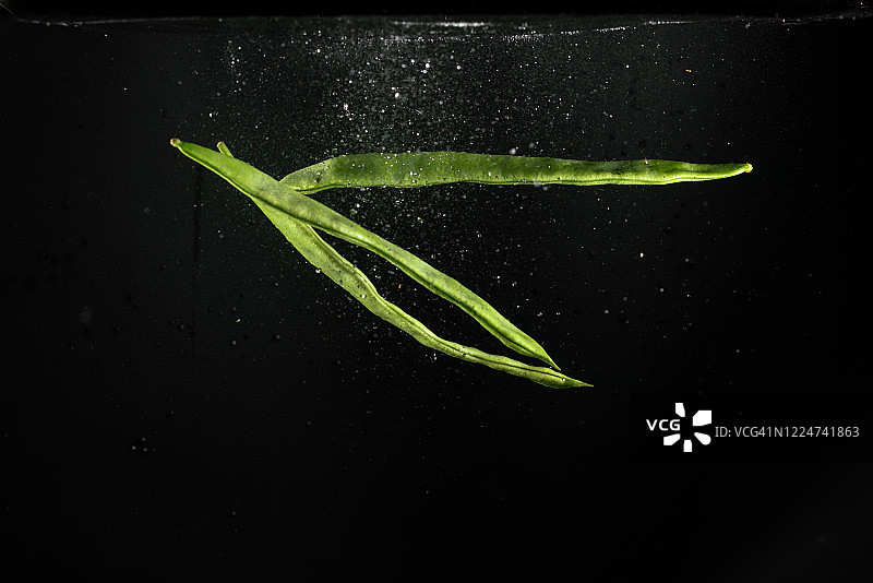 高速同步拍摄的刀豆落入水中图片素材