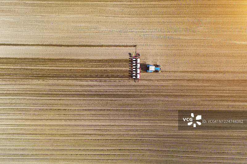 拖拉机在田间安装播种机航拍图片素材