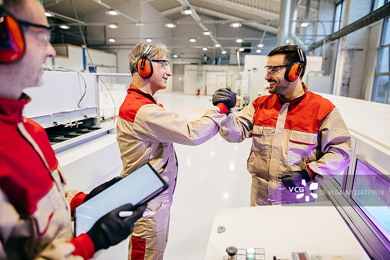 在工厂车间里工作的两名木匠握手图片素材