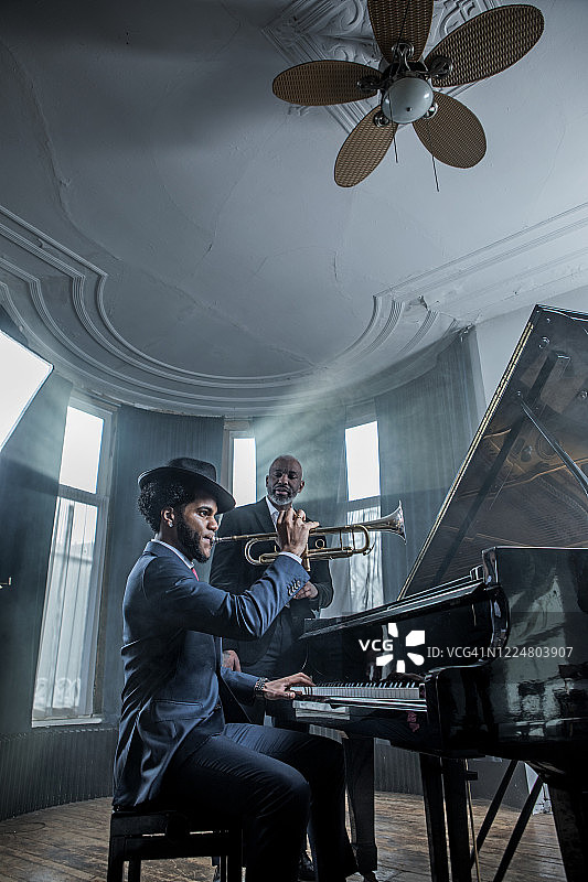 弹黑钢琴的男人和小号手图片素材