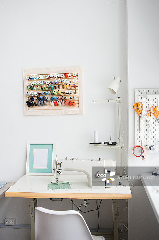 明亮的工作室内，女裁缝的工作台和电动缝纫机图片素材