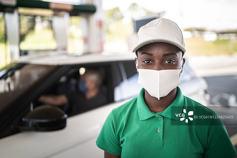 戴口罩工作的女加油站服务员肖像图片素材