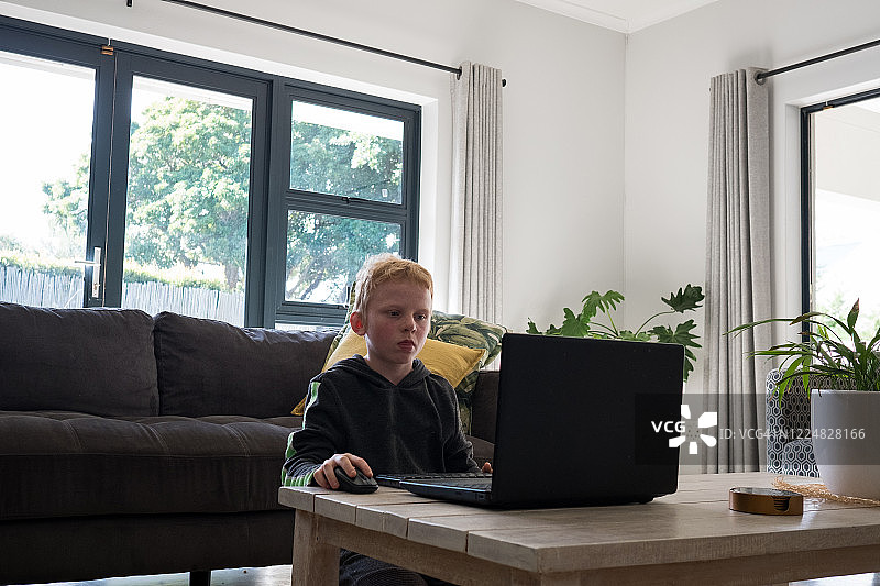 男孩坐在电脑前玩游戏图片素材