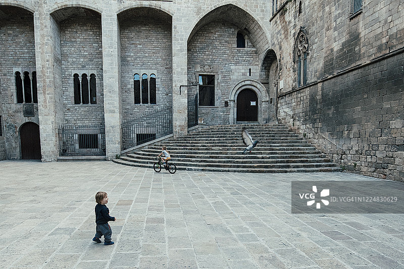 疫情封锁期间，孩子们在巴塞罗那空旷的广场上玩耍图片素材