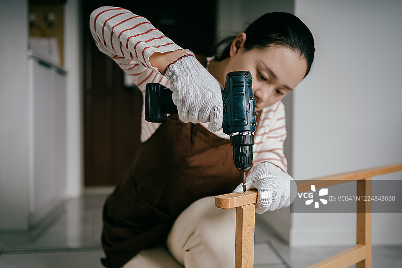 亚洲女性在家中组装桌子图片素材
