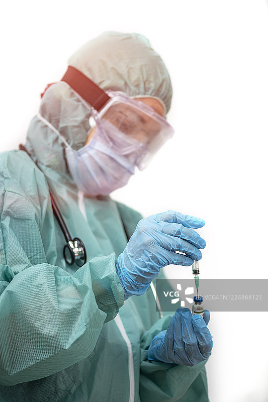 戴着防护口罩和手套，准备新冠疫苗的医生图片素材
