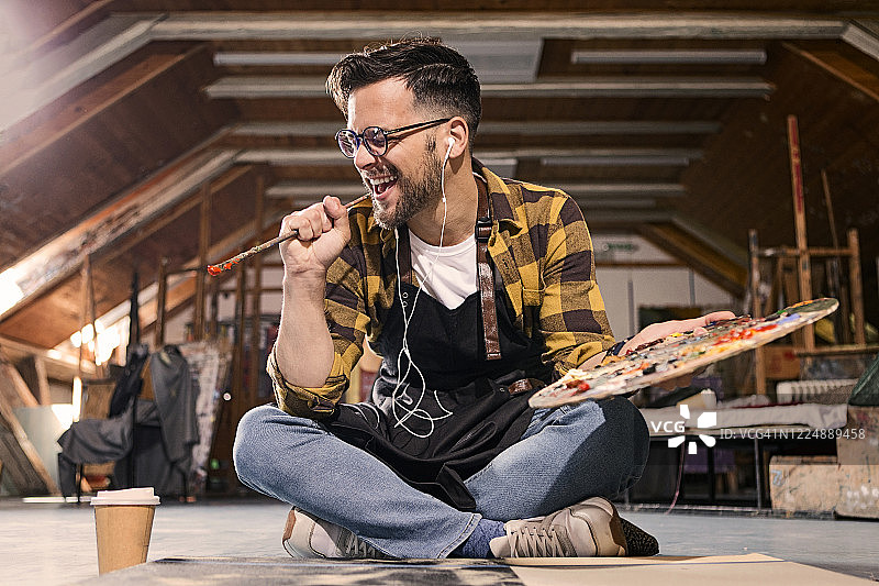 艺术家在工作室里拿着画笔唱歌图片素材