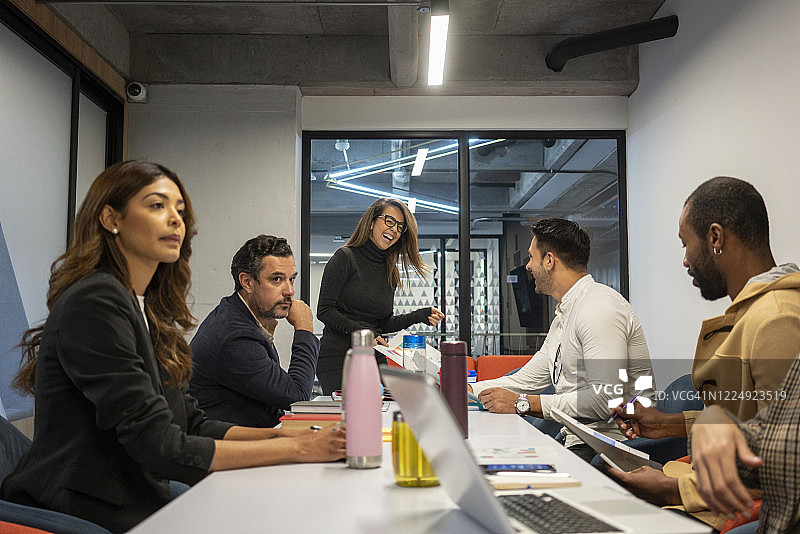拉丁裔女老板在员工会议上解释公司问题图片素材
