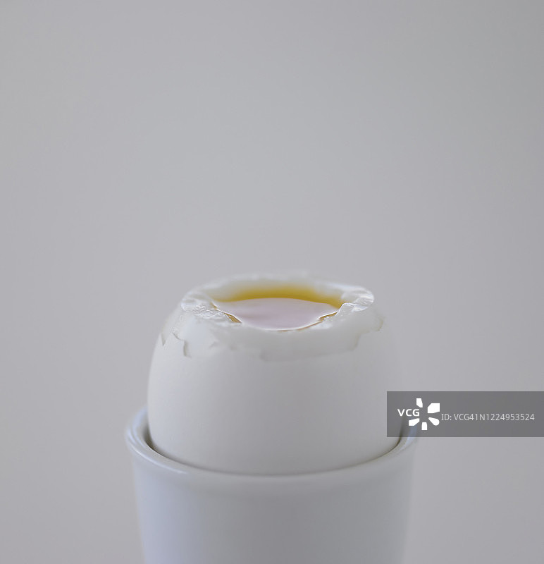 剥皮鸡蛋：露出蛋黄的杯装水煮鸡蛋图片素材