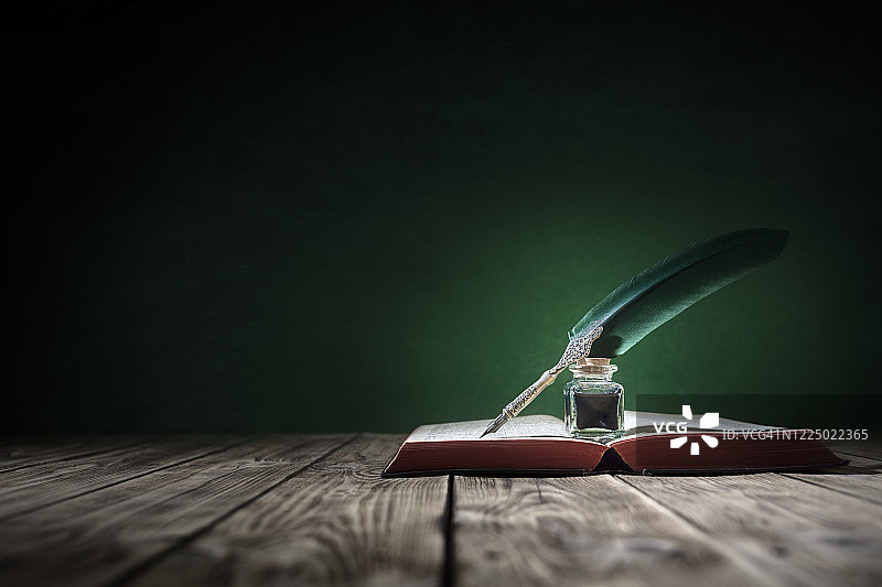 旧书背景上的羽毛笔和墨水瓶与复制空间图片素材