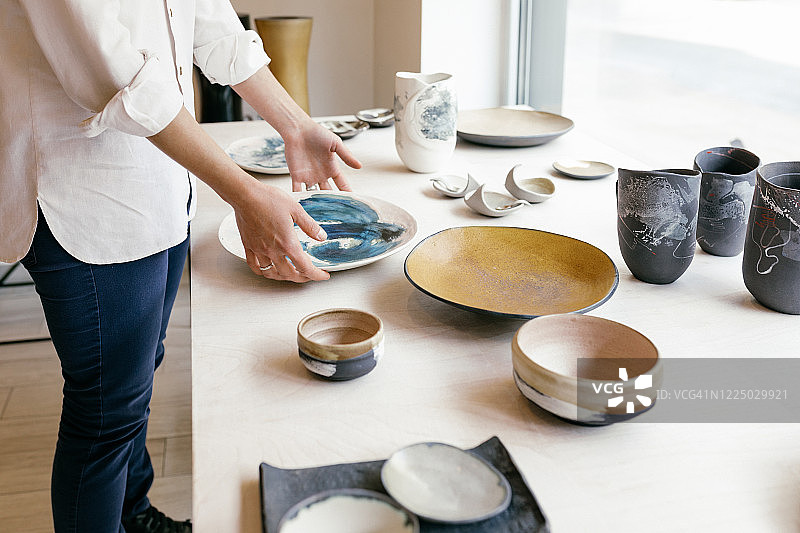 画廊里的陶瓷餐具 - 女商人出售陶器图片素材