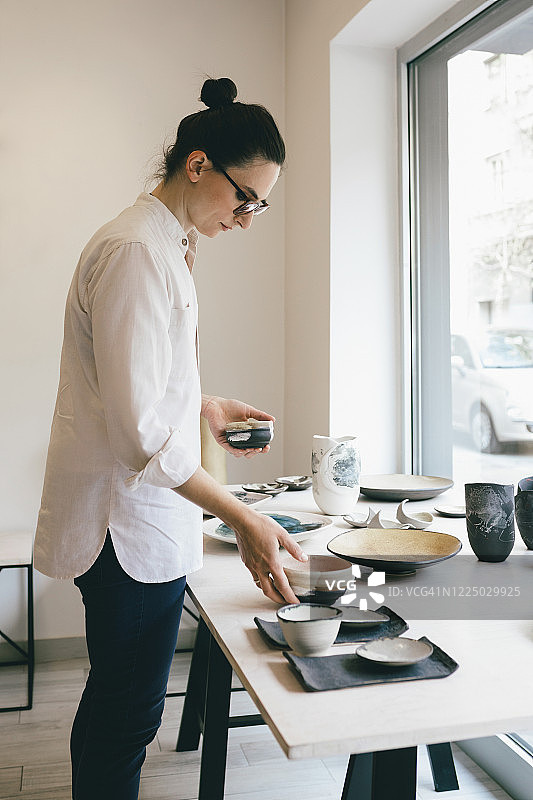 在画廊整理陶器的女人图片素材