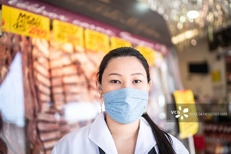 戴着口罩在肉店工作的女屠夫画像图片素材