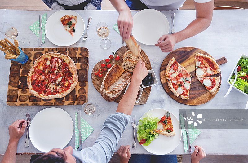 家人或朋友坐在摆满外卖食物的餐桌旁图片素材