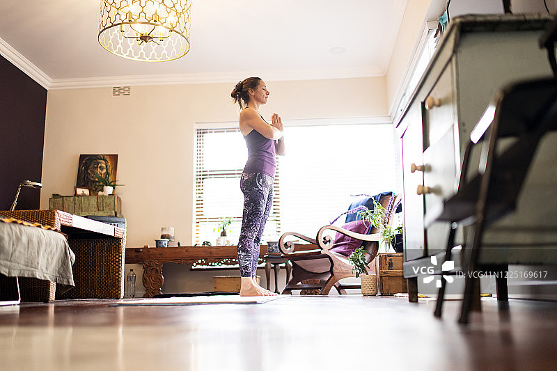 在客厅做瑜伽的女性全身低角度照片图片素材
