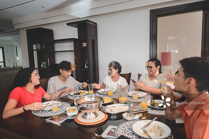 一家人在餐桌上享用巴西黑豆炖肉图片素材