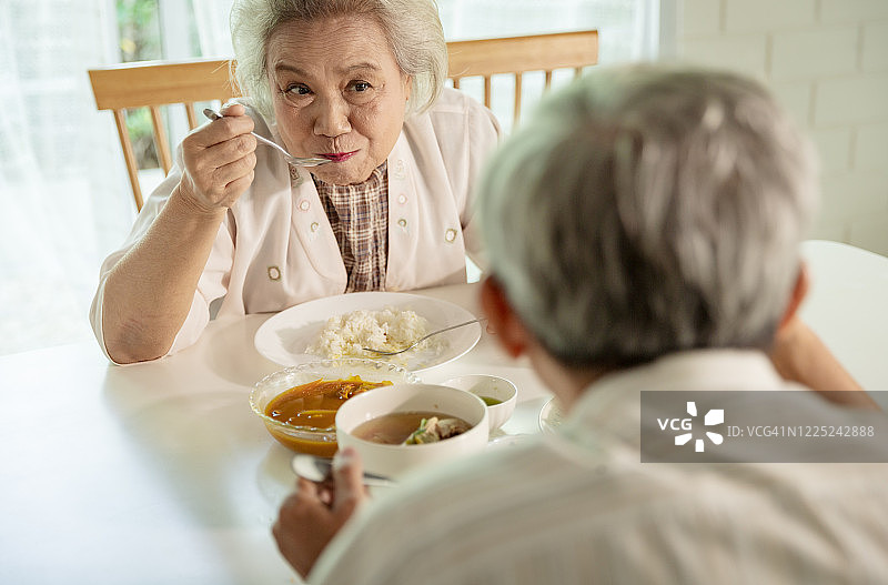 亚洲老年夫妇在家幸福地一起吃泰国菜图片素材