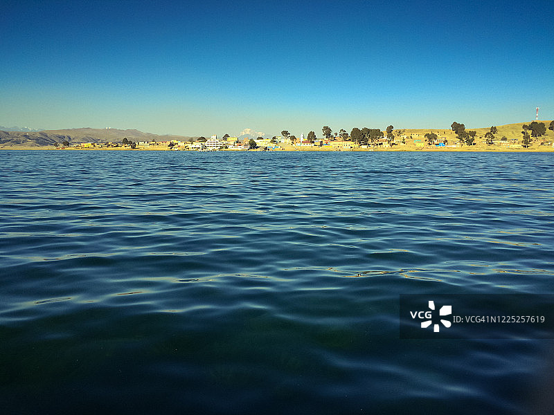 的的喀喀湖中部的梦幻海湾，背景是玻利维亚拉巴斯佩雷斯港的村庄图片素材