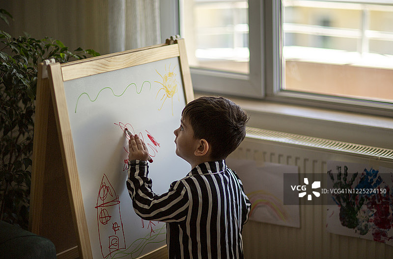 男孩在黑板上绘画图片素材