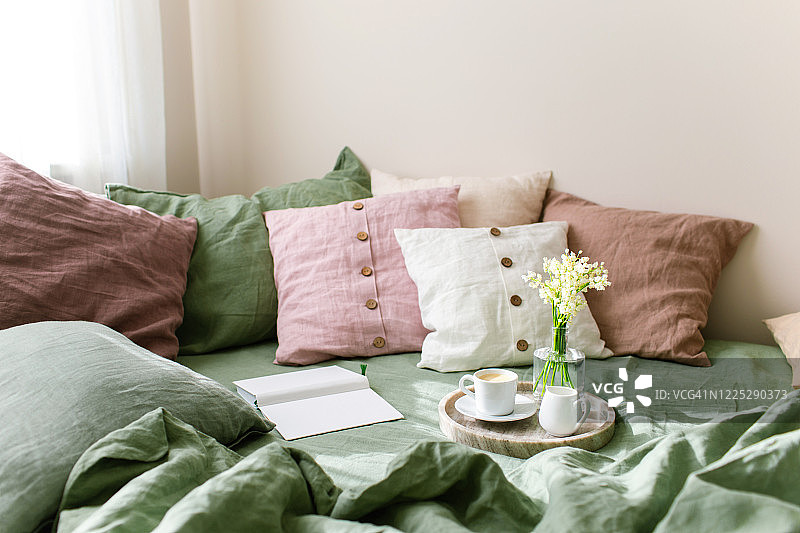 卧室室内设计：亮绿色亚麻床品与粉色靠垫图片素材