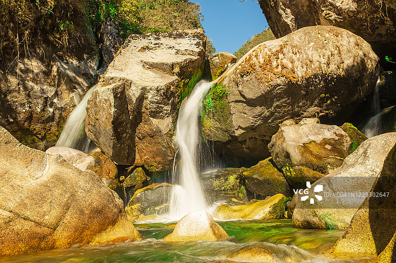前往玻利维亚拉巴斯埃尔乔罗的瀑布和河流周围岩石上的植被、植物、苔藓图片素材