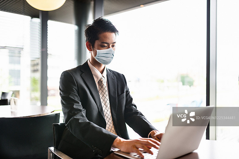 疫情期间戴着口罩工作的商人图片素材