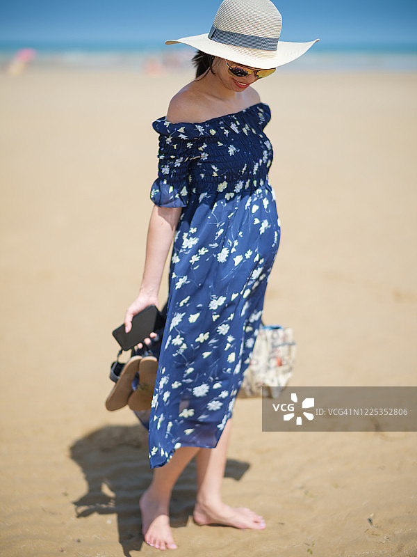 赤脚站在海滩上的亚洲孕妇图片素材