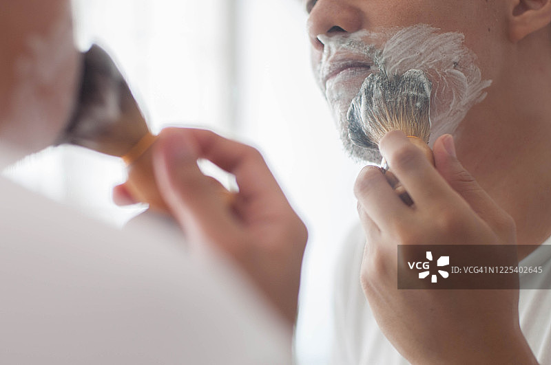 年轻的东南亚男人使用老式剃须工具图片素材