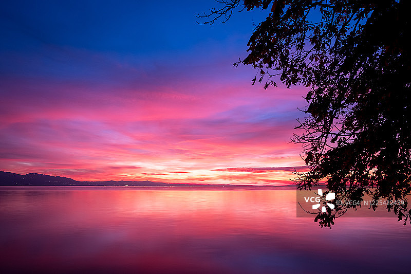 橙色阳光和粉色光芒下的深紫色云彩图片素材