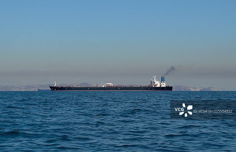 霍尔木兹海峡的冒烟大型油轮（伊朗波斯湾）图片素材