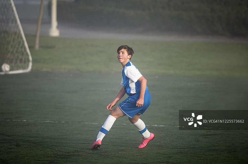 雾地准备防守的青少年足球运动员图片素材