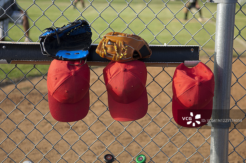 挂在T-Ball休息棚里的帽子和手套图片素材