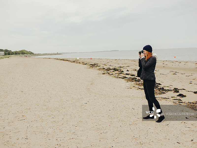 女人在苏格兰海滩上拍照图片素材