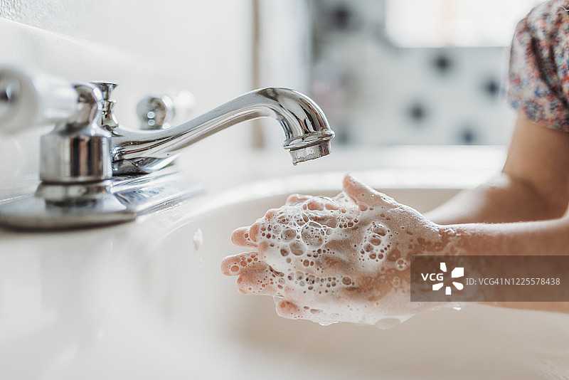 特写镜头：幼儿在水槽中用肥皂洗手图片素材