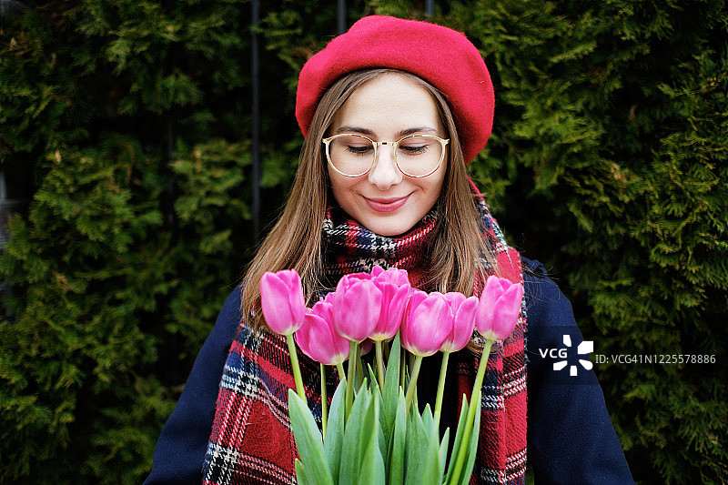 戴贝雷帽、手捧郁金香的年轻千禧一代法国女孩图片素材