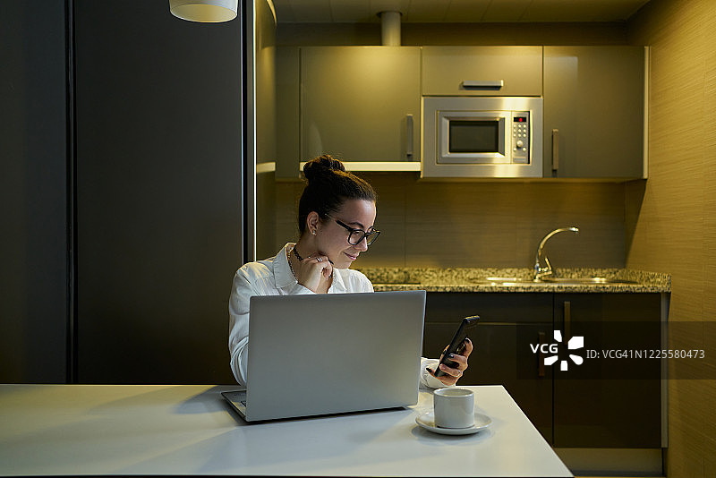 年轻女人晚上用笔记本电脑工作图片素材