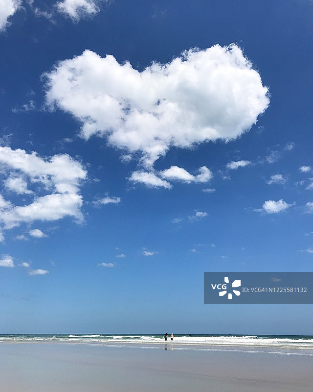 漂浮在空旷海滩上的心形云朵图片素材