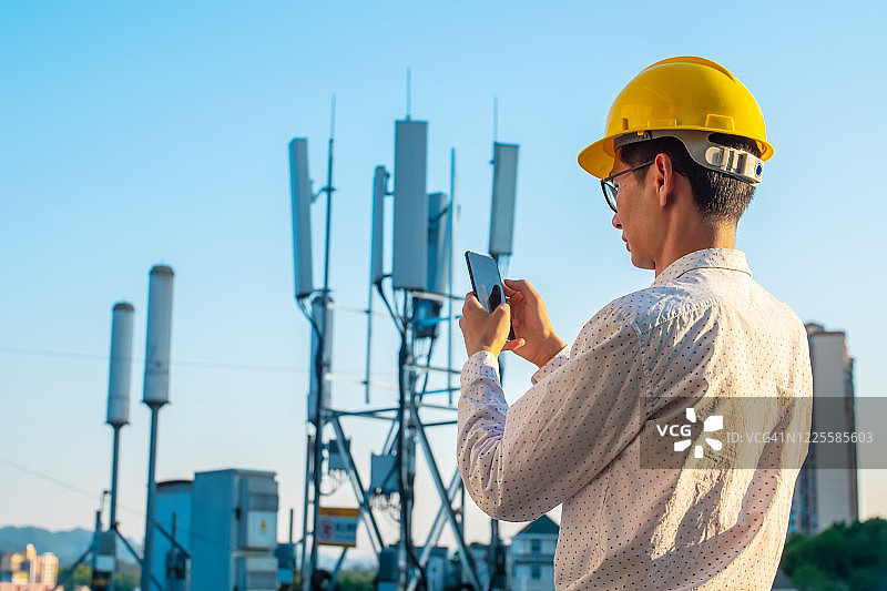 工程师手持手机测试通信塔图片素材
