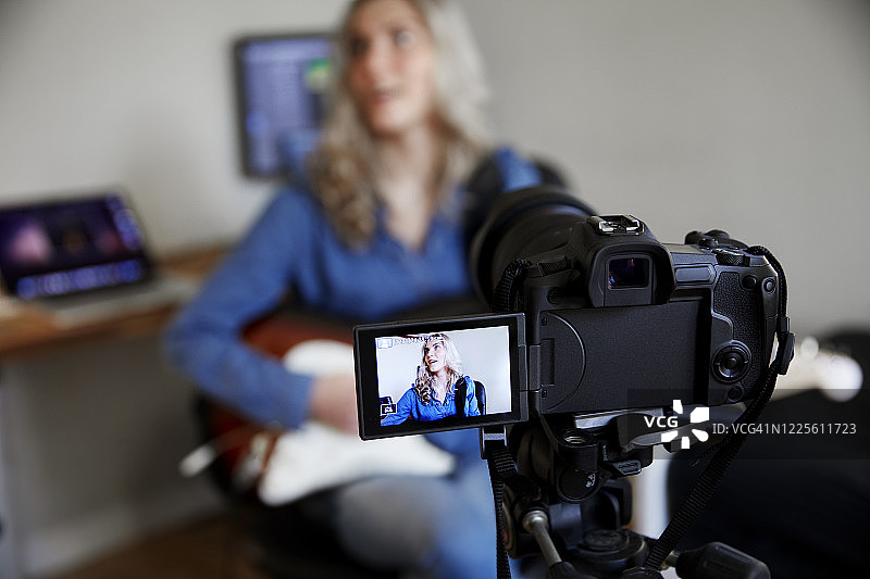 少女在网络摄像头前弹吉他图片素材