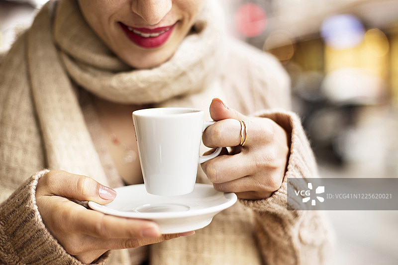 女士手持咖啡杯，白色马克杯中的浓缩咖啡图片素材