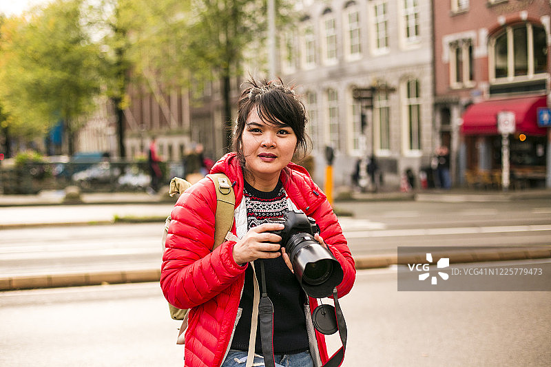 在阿姆斯特丹运河桥上拍照的亚洲年轻女性图片素材