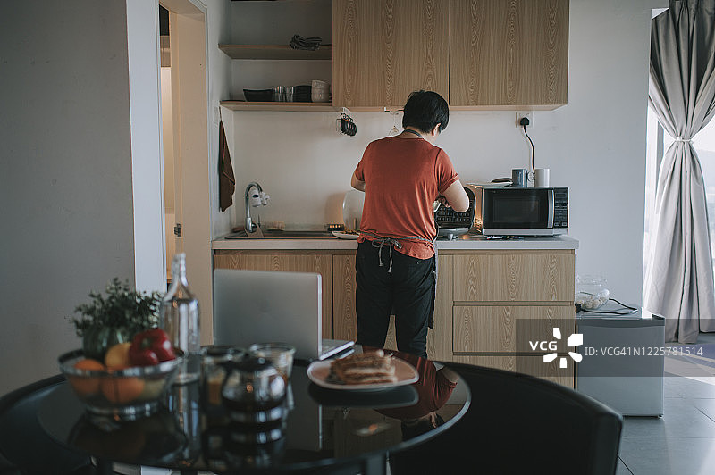 一位华人女性在厨房为家人准备华夫饼早餐图片素材