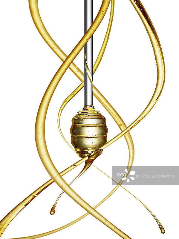 蜂蜜从蜂蜜棒滴落的特写，周围环绕着弯曲的蜂蜜条纹，在白色背景上隔离图片素材