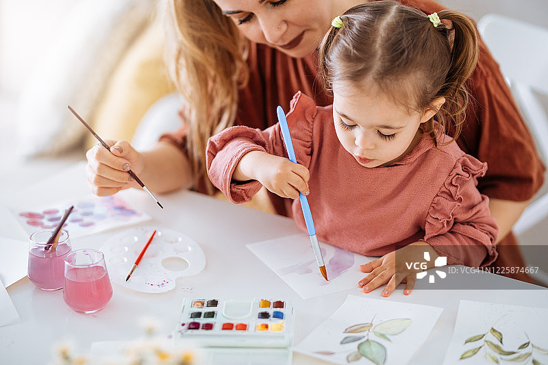 年轻的母亲和女儿在家中玩耍图片素材