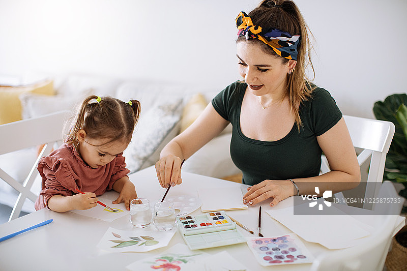 年轻的母亲和女儿在家中玩耍图片素材