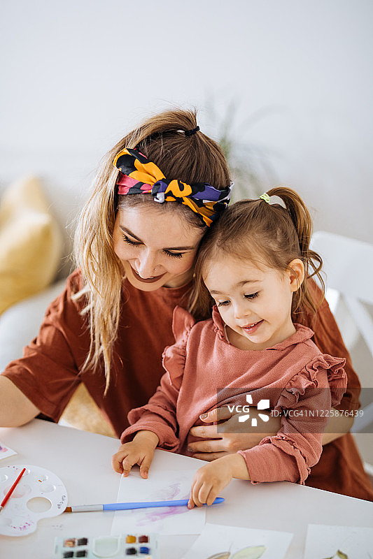 年轻的母亲和女儿在家中玩耍图片素材