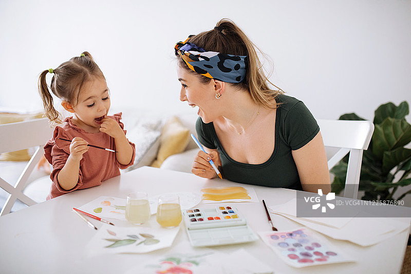 年轻的母亲和女儿在家中玩耍图片素材
