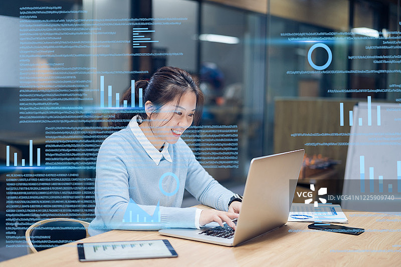 在虚拟屏幕上使用笔记本电脑的女商人图片素材