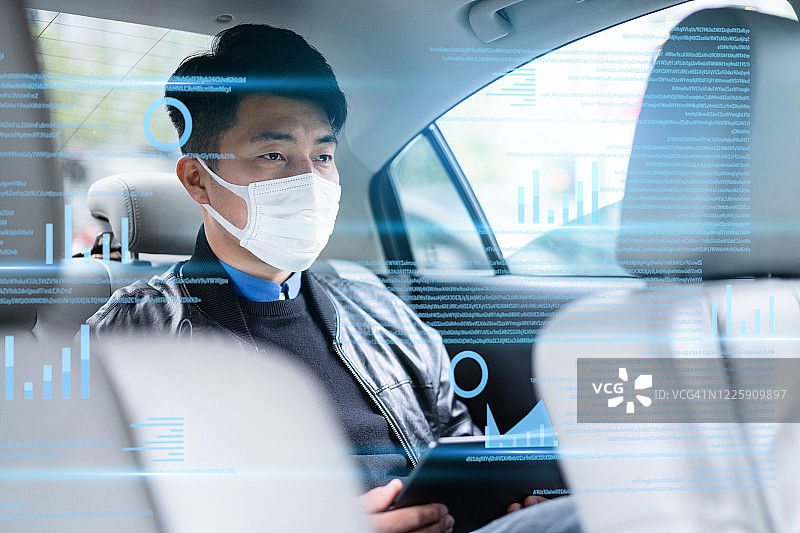 男人在车内虚拟视觉屏幕上使用平板电脑图片素材