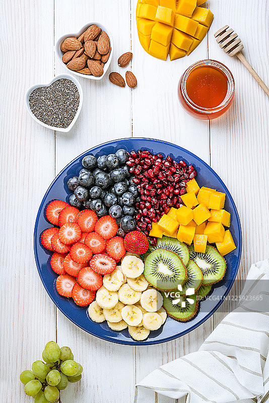 白色餐桌上俯拍的健康自制什锦水果沙拉拼盘图片素材